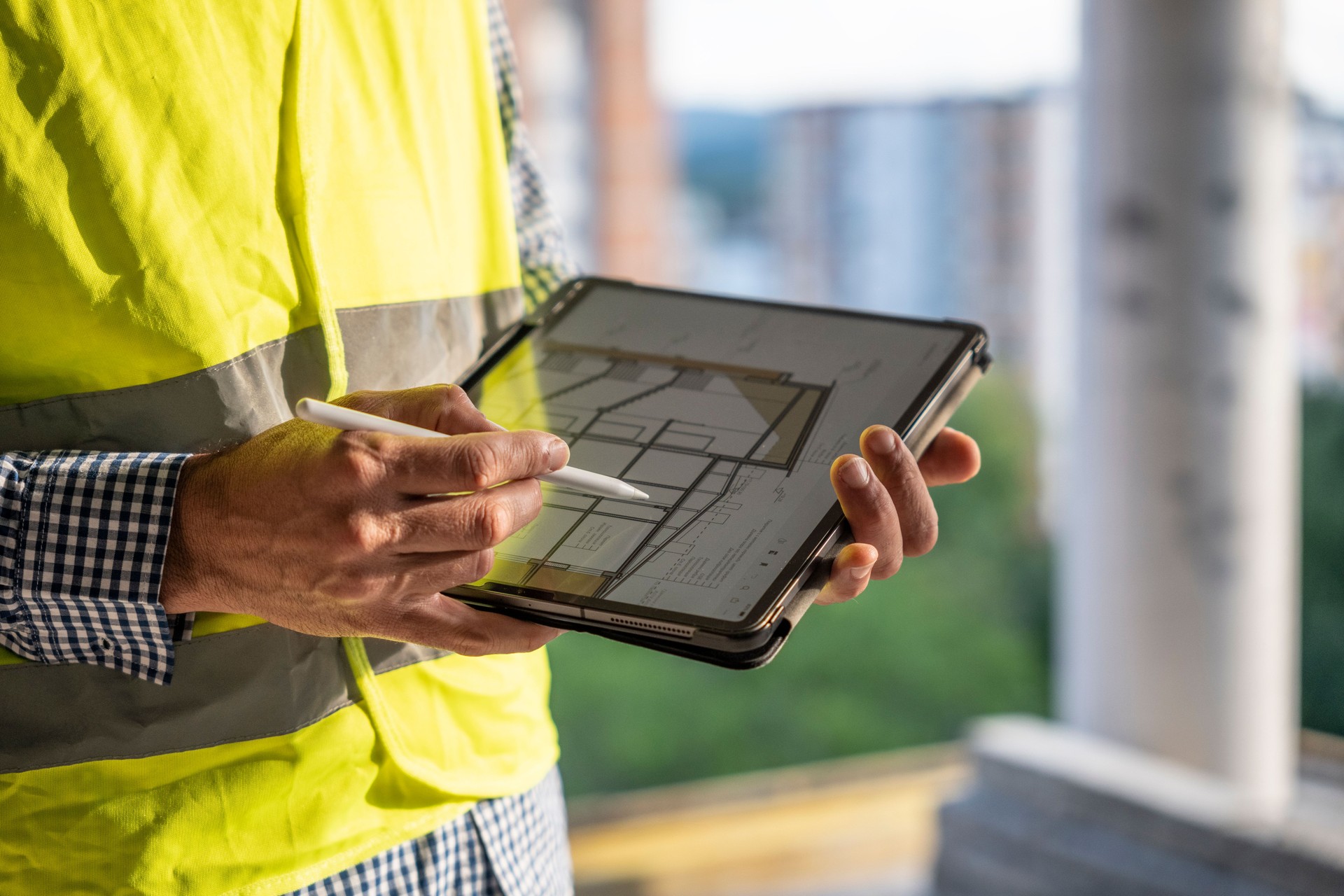 Civil engineer working with tablet on construction site, checking the work progress.